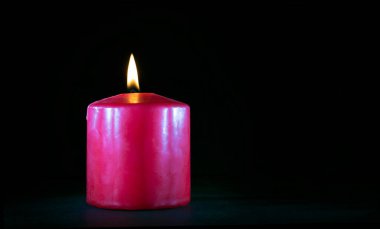 Siyah üzerine yanan kırmızı bir mum etrafına boşluk kopyala