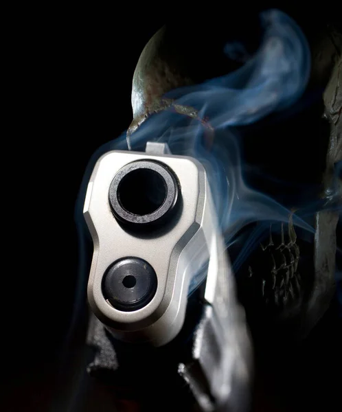 Smoking ghost gun handgun 3D illustration with a skul behind on a black background