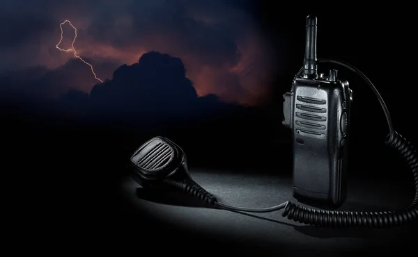 Strong electric storm behind a two way radio with mike