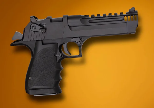 オレンジと日焼けの背景にある銃の後ろに示す大規模な半自動拳銃の影 — ストック写真