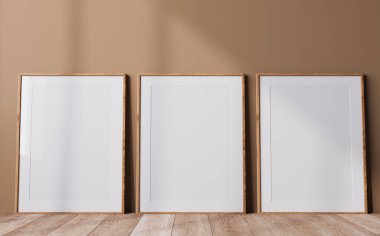 Poster çerçevesi tarafsız renklerle modellenir, bej arkaplanda üç ahşap çerçeve, minimal tasarım, 3D görüntüleme