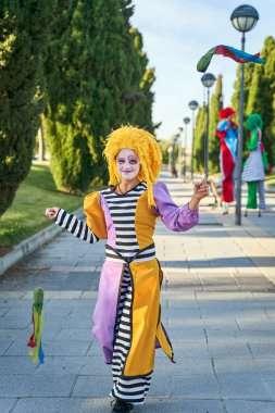 Gülen kadın palyaço parkta hokkabazlık yapıyor.