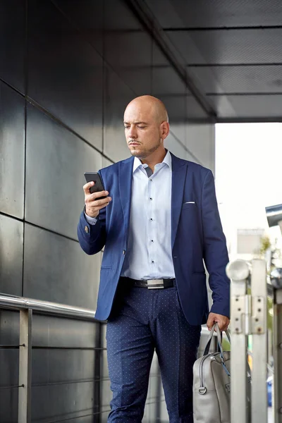 Empresário usando smartphone fora do edifício moderno — Fotografia de Stock