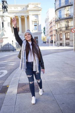 Şık genç bayan kaldırılmış koluyla taksiye biniyor.