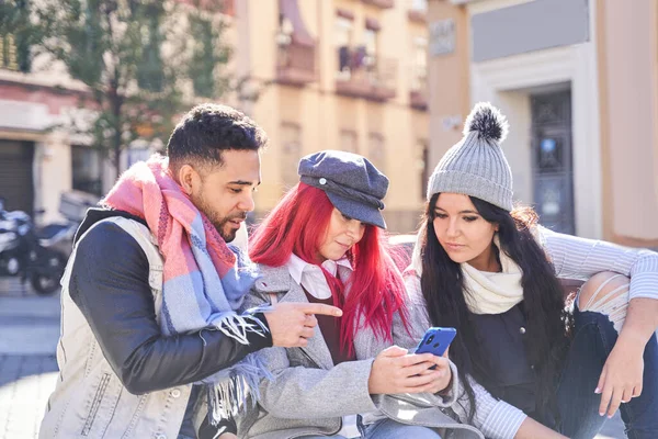 Diversos amigos usando teléfono inteligente en la calle de la ciudad — Foto de Stock