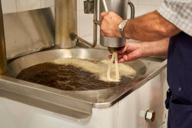 Ocakta kaynamış yağın içine churros hamuru dökerek yemek yapmak, tipik İspanyol kahvaltısı.. 