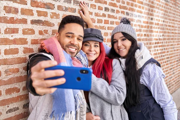 Prieteni multietnici zâmbind făcând selfie pe smartphone lângă peretele de cărămidă — Fotografie, imagine de stoc