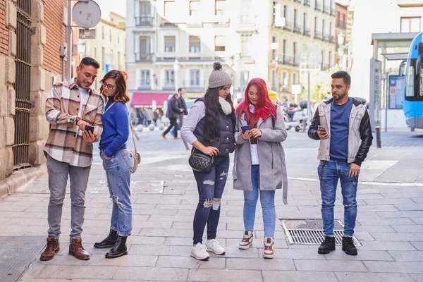 Prieteni multirasiale folosind telefoane mobile pe stradă — Fotografie, imagine de stoc