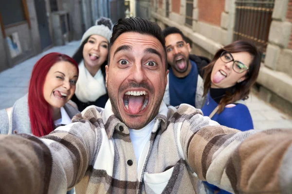 Gülümseyen çeşitli arkadaşlar ara sokakta selfie çekiyorlar.