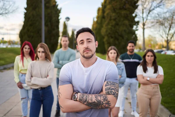 Hombre Mirando Serio Cámara Mientras Está Pie Delante Grupo Personas — Foto de Stock