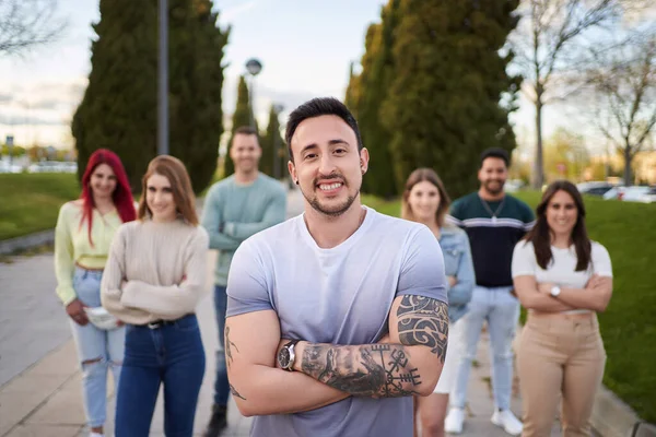 Hombre Con Los Brazos Tatuados Sonriendo Mirando Cámara Mientras Está — Foto de Stock