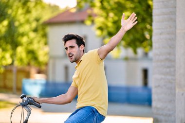 Dışarıda bisiklet sürerken gülümseyen mutlu bir adam. Ulaşım ve kentsel yaşam tarzı kavramı.