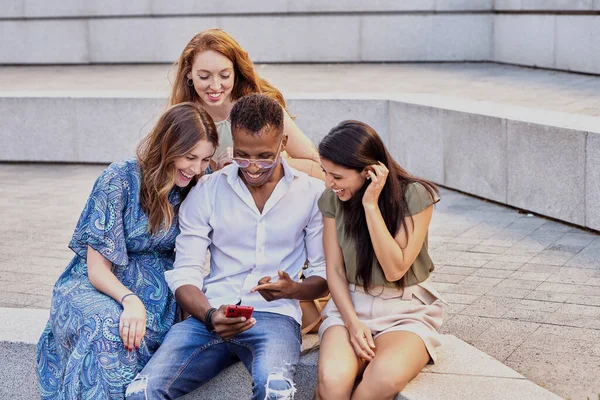 屋外に座っている間 一緒に携帯電話を使用して友人のグループ テクノロジー ソーシャルメディア 友情の概念 — ストック写真