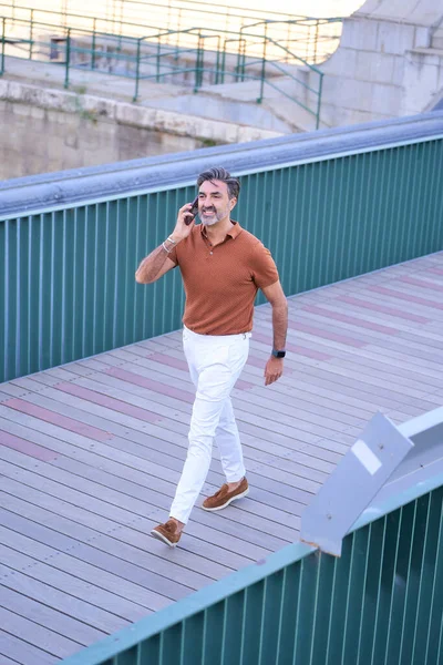 Pria Paruh Baya Yang Bergaya Berbicara Telepon Saat Berjalan Keluar — Stok Foto