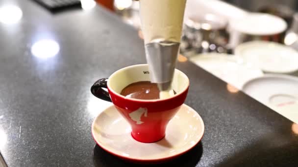 Налейте сливки на шоколад в чашке — стоковое видео