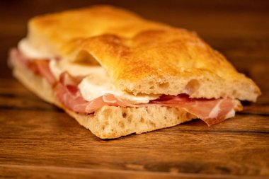 Tahta bir yüzeyde sebzeler ve sebzelerle doldurulmuş Focaccia.