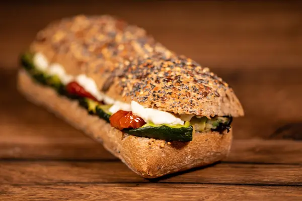 用腊肠和蔬菜装饰在木制表面的三明治 — 图库照片