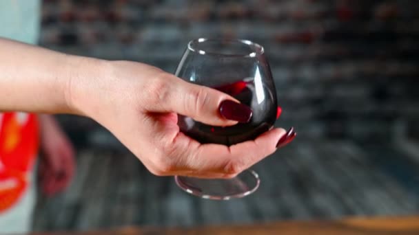 Vrouw roert wijn in een glas — Stockvideo