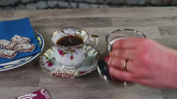 Женщина кладет сахар в чашку чая — стоковое видео