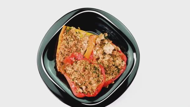 Black plate and cutlery with gratinated peppers — Stock Video