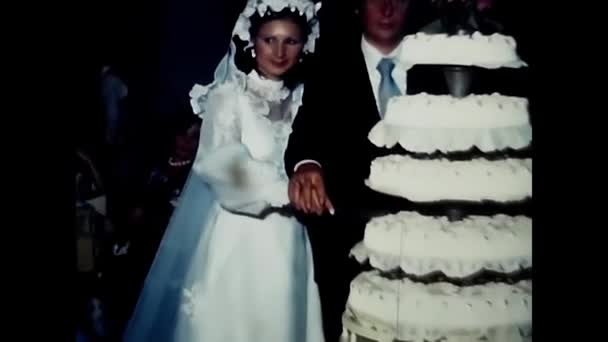 1970年5月イタリアのパレルモで結婚式が行われました ケーキをナイフで 恋人はケーキを食べる — ストック動画