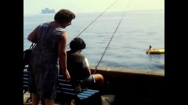 Büyük göl, Piedmont, 17 Mayıs 1980: Kadın iki balıkçının 80 'li yıllarda göl kenarına gidişini izliyor