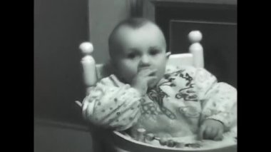 Milan, İtalya 10 Mayıs 1960: Küçük çocuk tavuk kemiği yiyor siyah ve beyaz 60 'lar