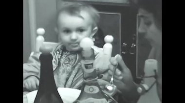 Milan, İtalya 10 Mayıs 1960: Siyah beyaz 60 'lı yıllarda kaşıkla yemek yiyen küçük bir kız.