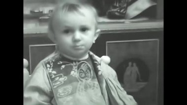 Milan, İtalya 10 Mayıs 1960: Siyah beyaz 60 'lı yıllarda kaşıkla yemek yiyen küçük bir kız.