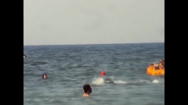 Palermo, İtalya 14 Ağustos 1977: insanlar 70 'lerde denizde banyo yapıyor ve yüzüyorlar.