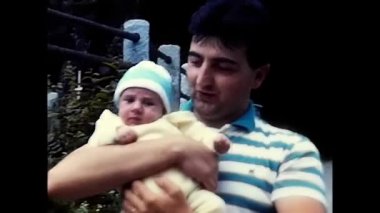 milan, italy march 18 1980:dad with newborn in his arms 80s