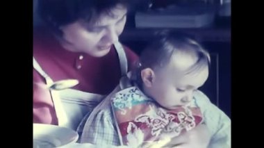 Milan, İtalya 12 Eylül 1960: Anne oğluna 60 'ların masasında yemek yediriyor.