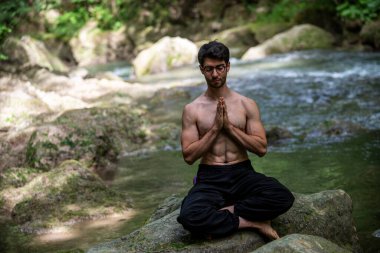 Yazın eyersiz yoga yapan adam.