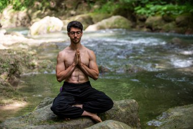 Yazın eyersiz yoga yapan adam.