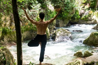 Yazın eyersiz yoga yapan adam.