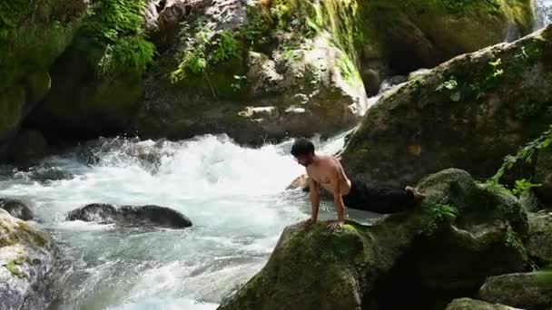 Τύπος Κάνει Γιόγκα Στις Όχθες Του Ποταμού Χωρίς Πουκάμισο — Αρχείο Βίντεο