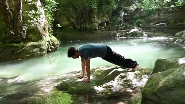 Chico Hace Yoga Las Orillas Del Río Plena Relajación — Vídeo de stock