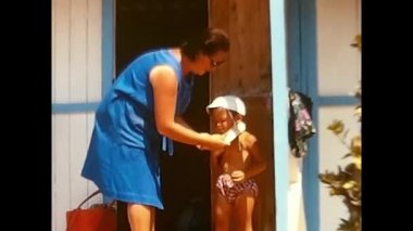 lavinio,italy june 10 1960:woman with child while dressing him by the sea 60s