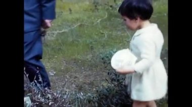 rome, italy april 18 1970:dad and daughter play in the countryside of the 70s