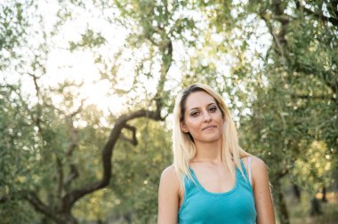 blonde girl in countryside in backlight on nature background