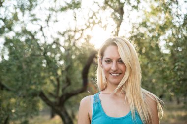 blonde girl in the countryside smiles on nature background