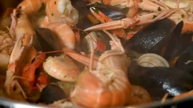 fish soup cooking in a pan with mixed fish and gravy