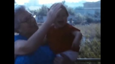 Rome, Italy February 1960 : grandmother with little girl on the balcony of happy house in the 60s