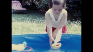 ravello, naples june 1960: little girl plays in the pool in the garden in the 60s