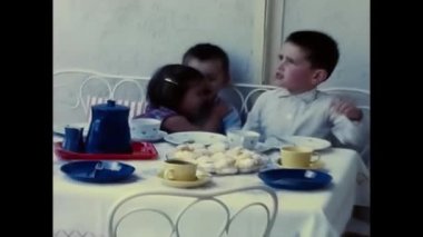 ravello, naples june 1960: children sitting at the table having breakfast in the 60s