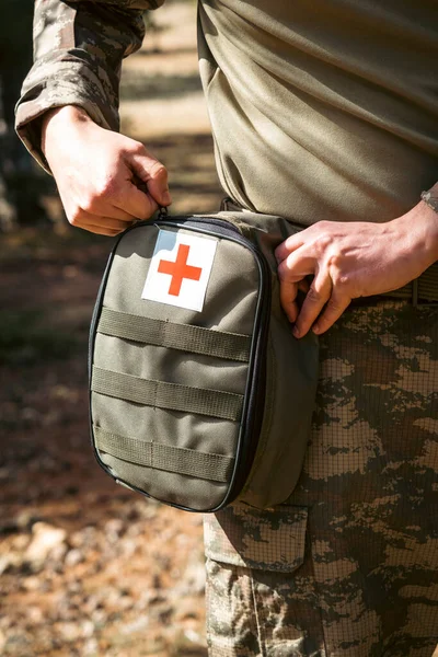 Military army first aid kit. Camouflaged soldier medic.