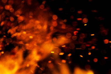 Siyah arkaplanda kıvılcımlar saçan ateş alevleri