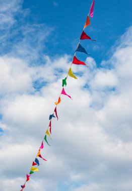 Mavi gökyüzüne karşı çok renkli bayraklar