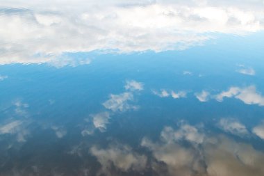 Suda yansıması olan beyaz bulutlar