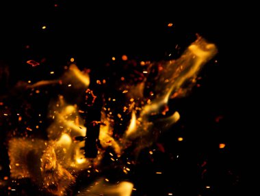 Siyah arkaplanda kıvılcımlar saçan ateş alevleri